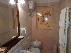 ein Badezimmer mit einem WC, einem Waschbecken und einem Spiegel in der Unterkunft Hotel Scalinatella in Angri
