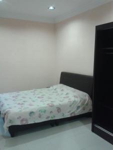 a bedroom with a bed with a floral sheet at Rose Apartment Kea Farm in Cameron Highlands