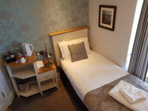 
a bedroom with a bed, a desk and a lamp at Penhelig Arms in Aberdyfi
