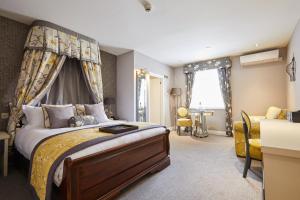 a bedroom with a large bed with a canopy at Woughton House Hotel, WorldHotels Distinctive in Milton Keynes +115 photos