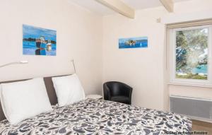 - une chambre avec un lit, une chaise et une fenêtre dans l'établissement Le Gîte du Port, à Roscoff