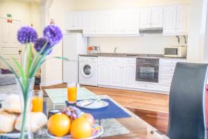 a kitchen with a table with fruit and purple flowers at Arcadas Cozy Apartments - AV in Funchal