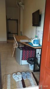 a room with a table and a desk with a table and shoes at Ban Lom Jen Homestay in Chiang Rai