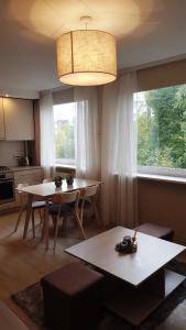 a living room with two tables and a large window at Apartamentai Vilniaus Street in Šiauliai