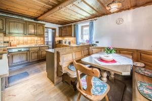 een keuken met houten kasten en een tafel en stoelen bij Almliesl RAUR-437 in Rauris