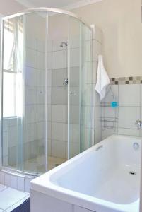 a bathroom with a tub and a glass shower at Tranquil Guest House in Dundee