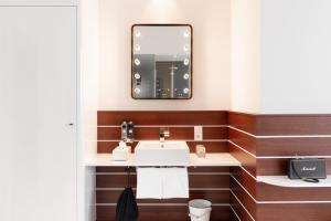 
a bathroom with a sink, toilet and mirror at Ruby Lotti Hotel Hamburg in Hamburg
