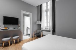 um quarto com uma cama e uma secretária com uma televisão em Palazzo Cambiaso em Gênova