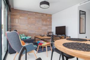 uma sala de estar com mesas e cadeiras e uma televisão em Apartment Vistamar I em Campoamor