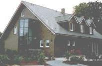 a large house with a black roof at Gästehaus Hankhausen in Rastede