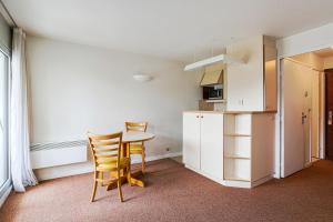 Una cocina con una mesa y sillas en una habitación. en Residence Les Tamaris - maeva Home, en Trouville-sur-Mer