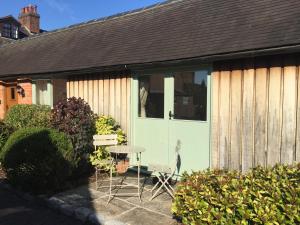 una porta verde del garage con tavolo in cortile di Oak Barn a Wigginton