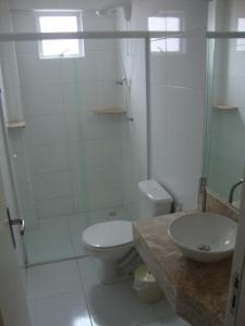 Un baño con inodoro, ducha y lavabo. en apartamento aluguel temporada bombinhas, en Bombinhas 7 fotos más