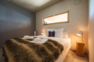 Le Holzberg et ses Suites في Osenbach: غرفة نوم بسرير كبير مع بطانيه