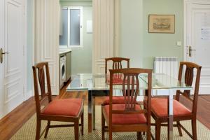 Un comedor con una mesa de cristal y sillas. en Koxka - Basque Stay, en San Sebastián