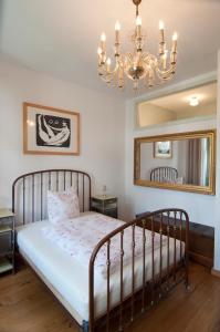 una camera da letto con un letto con un lampadario a braccio e uno specchio di Sachsenperle a Dresda