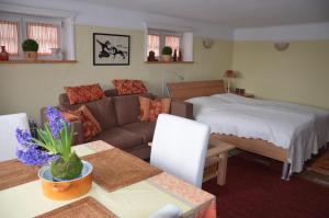 ein Wohnzimmer mit einem Sofa und einem Bett in der Unterkunft Ferienwohnungen Himmelsstübchen und Gartenstübchen in Plön