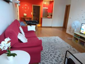 a living room with a red couch and a table at Apartamento Gabierrota in Rentería