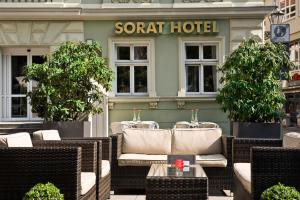a restaurant with wicker chairs and tables in front of a hotel at SORAT Hotel Cottbus in Cottbus