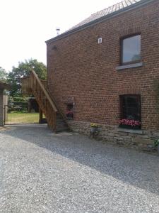 un edificio de ladrillo con una escalera en su lateral en Le p'tit gîte d'Enhet, en Ciney