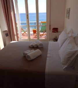 a bedroom with towels on a bed with a view of the ocean at Le Casasse "Paradiso" in Varigotti