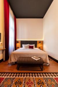 a bedroom with a large bed and a red curtain at Hotel Rum Budapest in Budapest