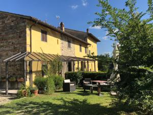 a yellow house with a table and chairs in the yard at Tenuta dei Cavalieri in Molino del Piano