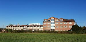 ein Hotelgebäude mit einem Feld davor in der Unterkunft Confour Hotel in Burgdorf