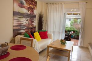 a living room with a white couch with colorful pillows at Cozy Maisonette in Kamena Vourla