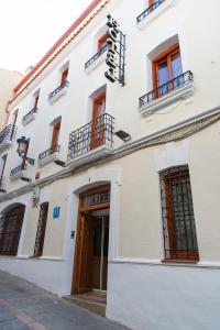 a white building with a white door and windows at Hotel Castilla in Cáceres