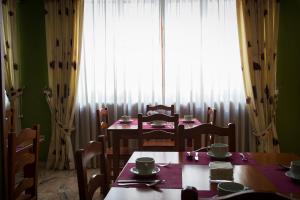 a dining room with a table and chairs and a window at Hotel Castilla in Cáceres