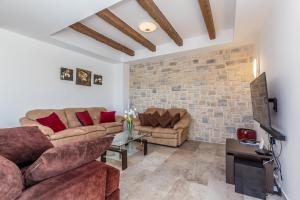 a living room with two couches and a brick wall at Villa Lurda Linardici Krk in Linardići