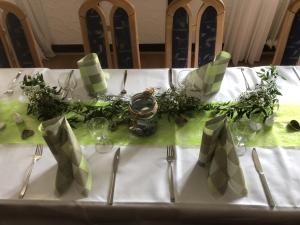 a table with a white table cloth with forks and knives at Landgasthof-Bikerhotel Arnold in Battenberg