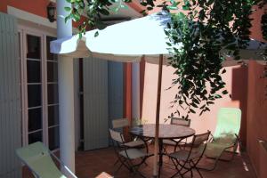 una mesa y sillas en un patio con sombrilla en Appartement Avec Patio Et Garage Centre Ville Et Plage en Sanary-sur-Mer