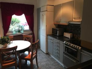 a kitchen with a table and a small table and a table and a window at BoSmart Apartments in Gothenburg
