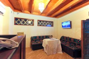 una sala de espera con mesa y 2 sillas en Hotel SHOHRUD, en Bukhara