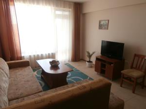 een woonkamer met een bank, een tafel en een tv bij Villa Rouge in Sozopol