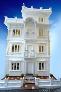 a white facade of a building with potted plants at Villino Kalipparambil in Ernakulam