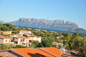 a view of a town with a lake and mountains at Sardegna Pittulongu in Olbia