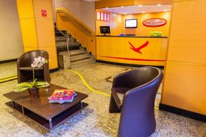 a lobby with two chairs and a table and stairs at Hotel Vermont Ipanema in Rio de Janeiro