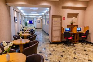 a waiting room with tables and chairs and computers at Hotel Vermont Ipanema in Rio de Janeiro