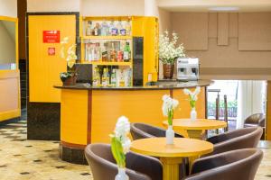 a restaurant with tables and chairs and a yellow bar at Hotel Vermont Ipanema in Rio de Janeiro