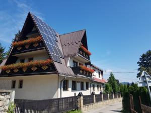 une maison avec un panneau solaire sur le toit dans l'établissement Willa u Słodkiego, à Zakopane