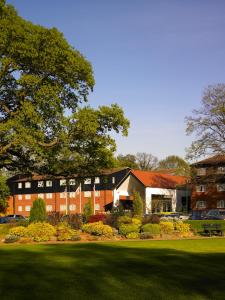 un edificio con césped verde frente a un edificio en Meon Valley Hotel, Golf & Country Club en Shedfield