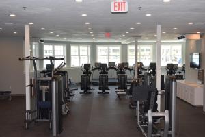 un gimnasio con filas de bicicletas estáticas y cintas de correr en The Club at New Seabury en Mashpee