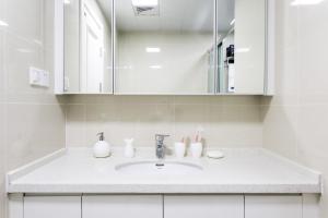 a white bathroom with a sink and a mirror at Wuhan Hongshan·Jiedaokou· Locals Apartment 00116860 in Wuhan +23 photos