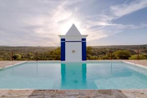 a swimming pool with a blue and white tower at Monte da Lapa in Arraiolos
