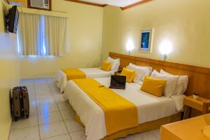 a hotel room with two beds with a laptop on it at Hotel Vermont Ipanema in Rio de Janeiro