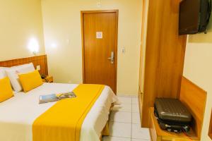 a hotel room with a bed and a television at Hotel Vermont Ipanema in Rio de Janeiro