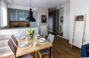 una cucina e una sala da pranzo con tavolo e sedie in legno di Apartamenty City Tower od WroclawApartament-pl a Breslavia